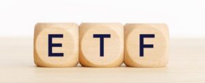 Three wooden blocks spell "ETF," a traditional alternative to buying crypto like Bitcoin on Coinmama.