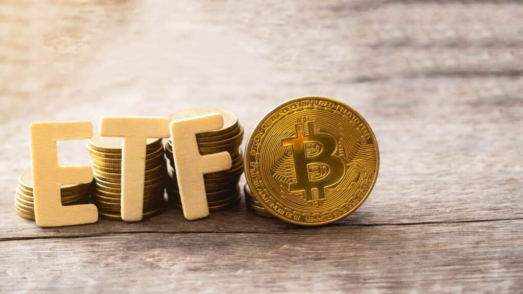 Stacks of coins spell "ETF," with a Bitcoin symbol urging you to buy crypto via Coinmama.