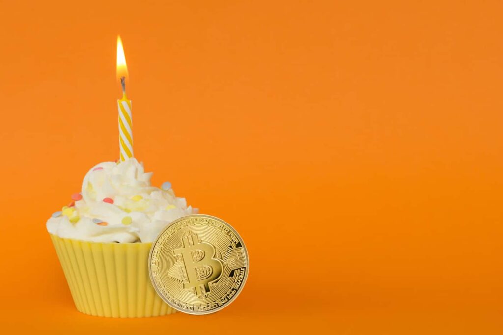 Buy Bitcoin on Coinmama: Celebrate with a cupcake, lit candle, and BTC symbol coin.