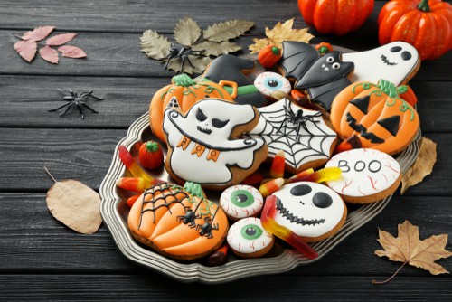 Halloween cookies on dark wood, surrounded by festive decorations—ideal while browsing Coinmama to buy Bitcoin.