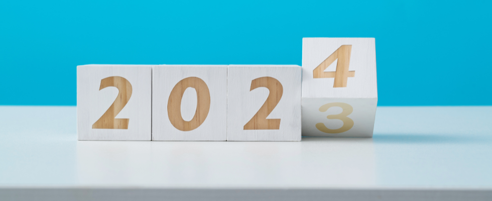 Four wooden blocks show "2023" transitioning to "2024," similar to Bitcoin's value changes. Buy crypto on Coinmama.