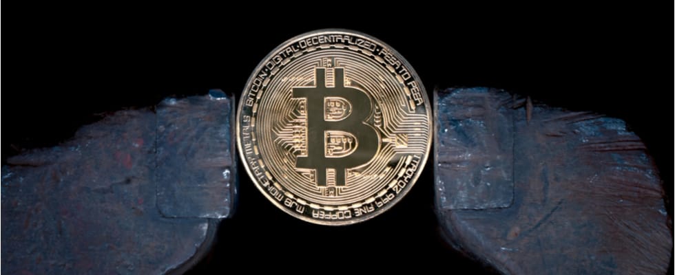 A detailed Bitcoin coin, clamped against a black background, showcases buy BTC allure. Coinmama ready!