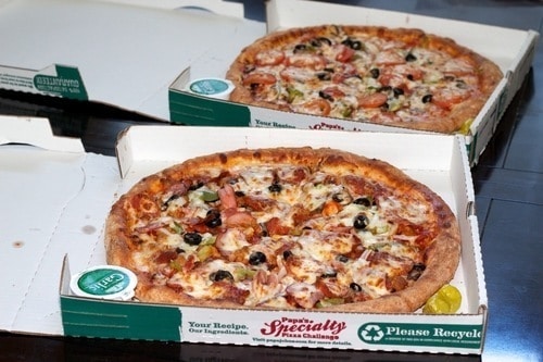 Two open "Papa John's" pizza boxes with toppings like olives and meat. Enjoy while you buy bitcoin on Coinmama.