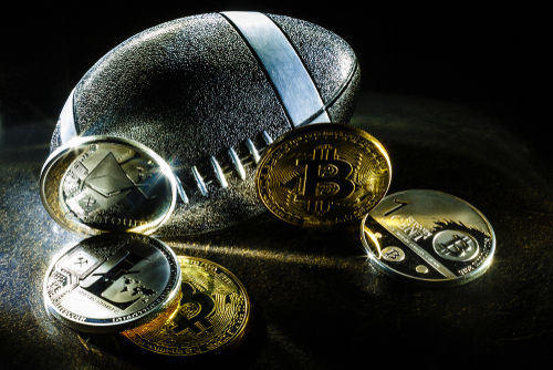 A metallic football with cryptocurrency coins, including Bitcoin. Ideal for buying crypto on Coinmama.
