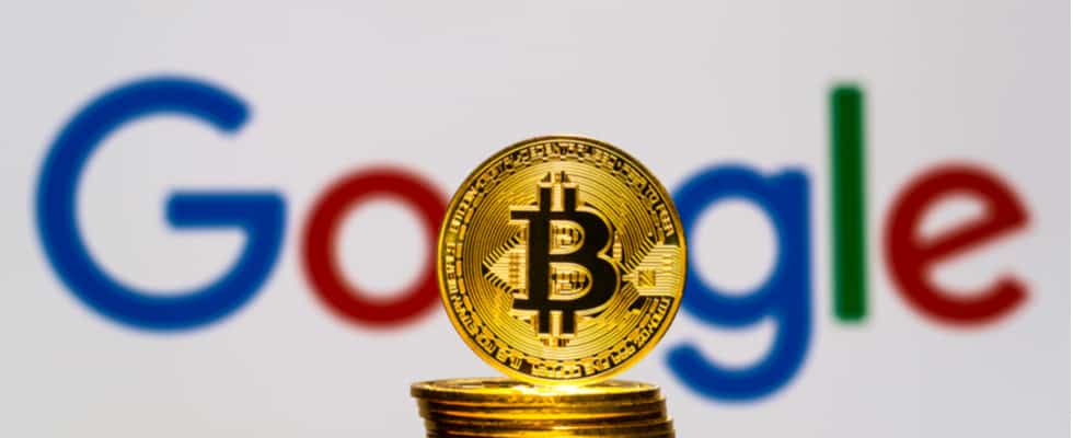 A stack of gold Bitcoin coins is placed in front of a blurred Google logo. Coinmama makes it easy to buy bitcoin.